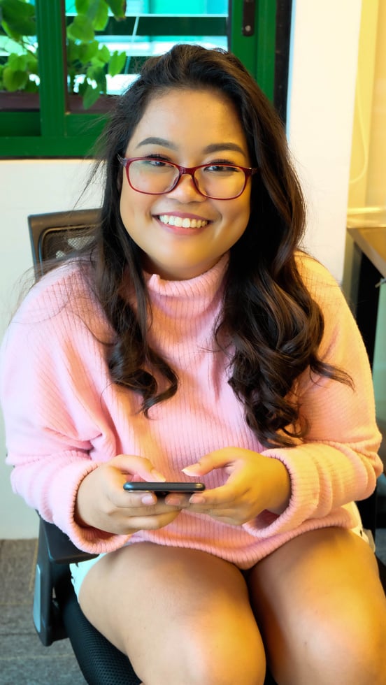 Smiling Woman Using Smartphone in the Office